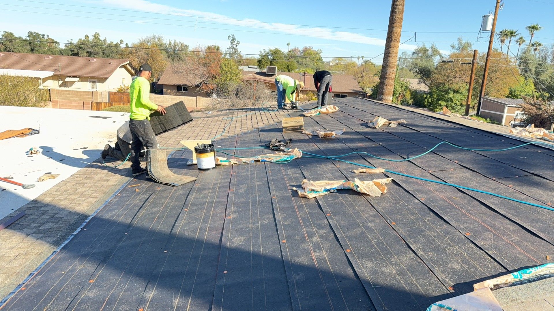 Architectural shingle · Tempe · April 2026 — Wind-lifted shingles and torn tabs along a rake edge after monsoon gusts — homeowner spotted grit in the gutters.