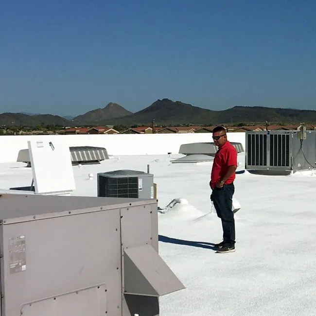 A KY-KO Roofing manager reviews his team's work on this commercial building's foam roof.