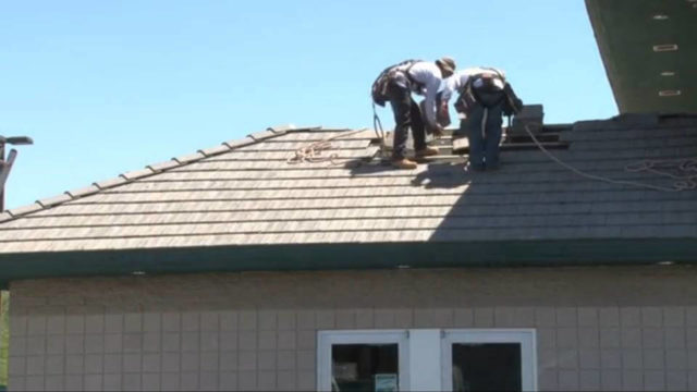 Our roofers, wearing safety harnesses for their protection, complete repairs on the tile roof of this Valley business.