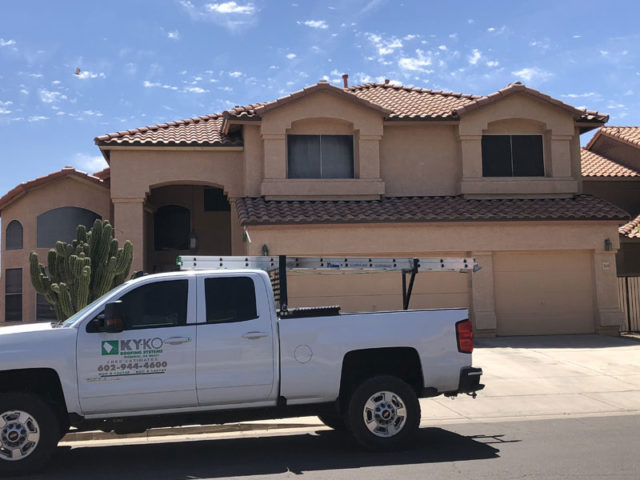A KY-KO Roofing truck sits parked in front of this two-story home here in Phoenix ahead of their free roofing checkup.