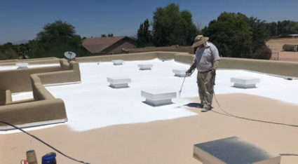 A KY-KO roofer apply spray foam roofing to the flat roof of this Phoenix, AZ home.