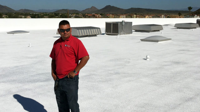 A KY-KO roofing specialist surveys the top of this office building's foam roof after completing their quality assurance review.